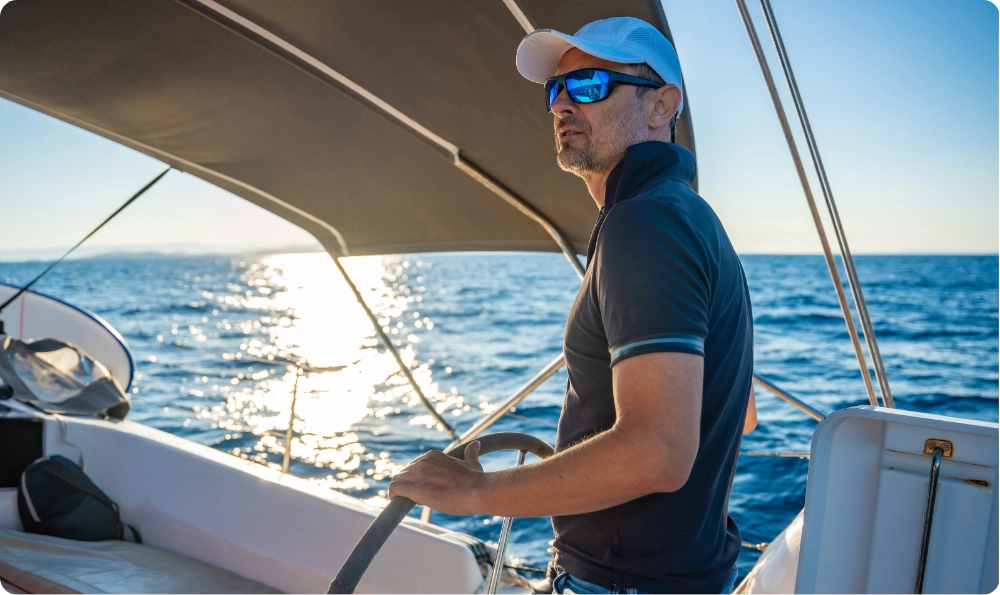 Professional skipper at the helm of a sailboat cruising in the Mediterranean